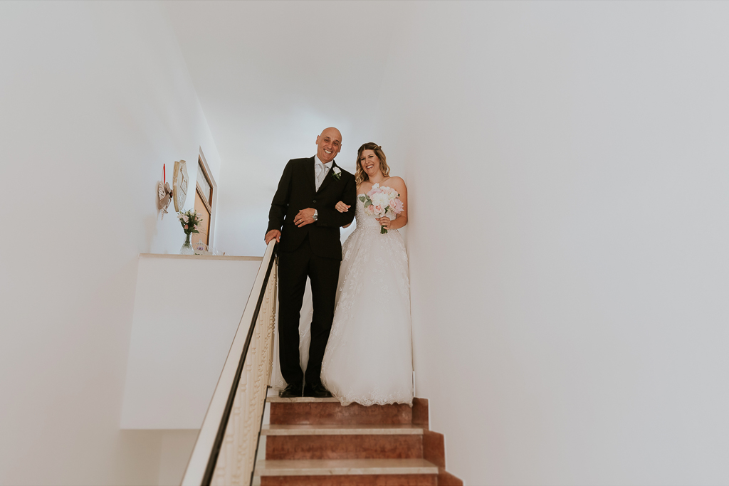 la sposa scende le scale di casa con il padre