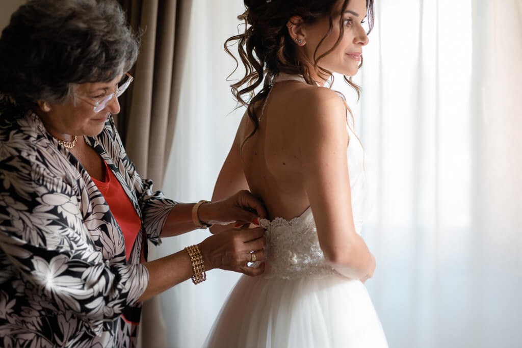 la mamma chiude abito della sposa