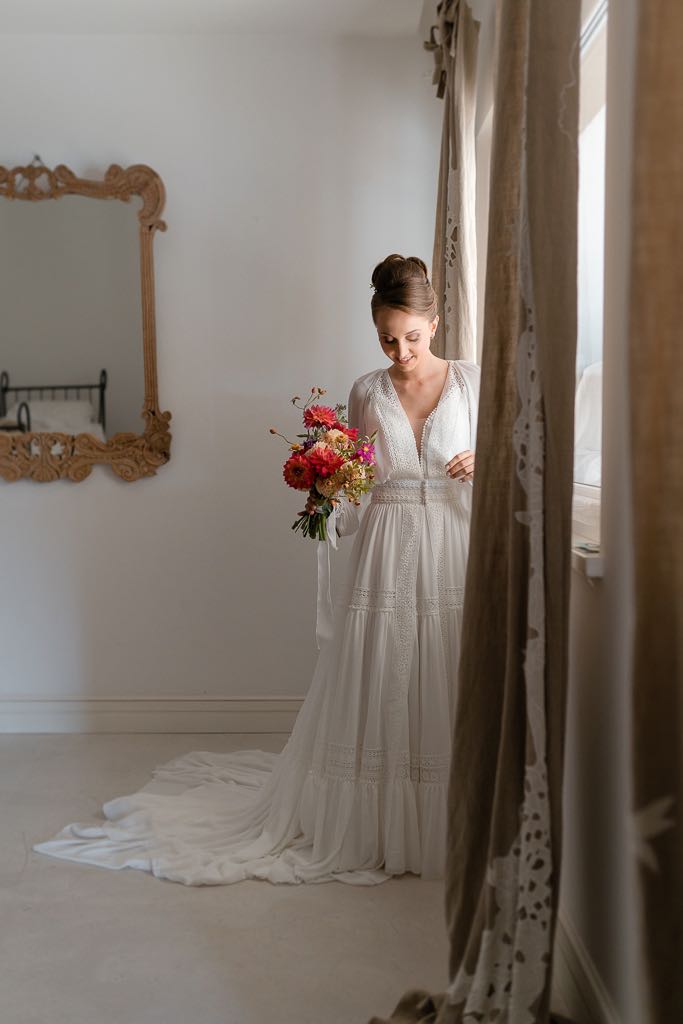 la sposa indossa il suo abito vicino alla finestra