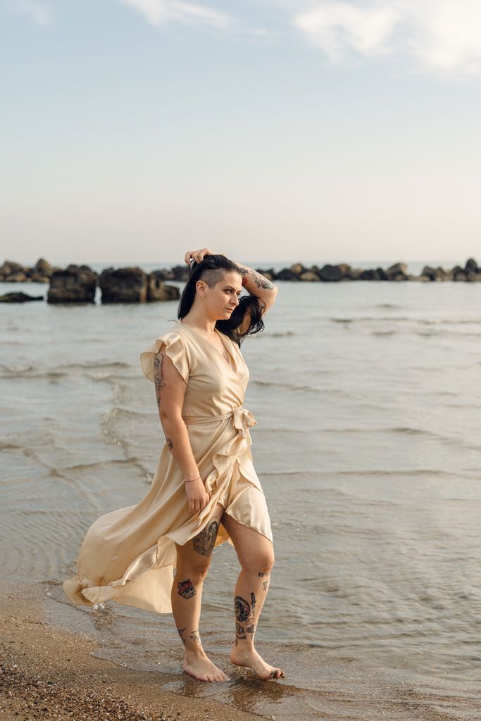 ragazza con i tatuaggi sulla spiaggia