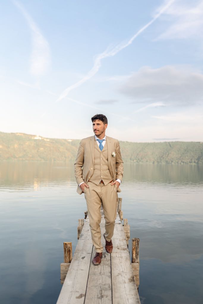 lo sposo passeggia sul molo di legno sul lago