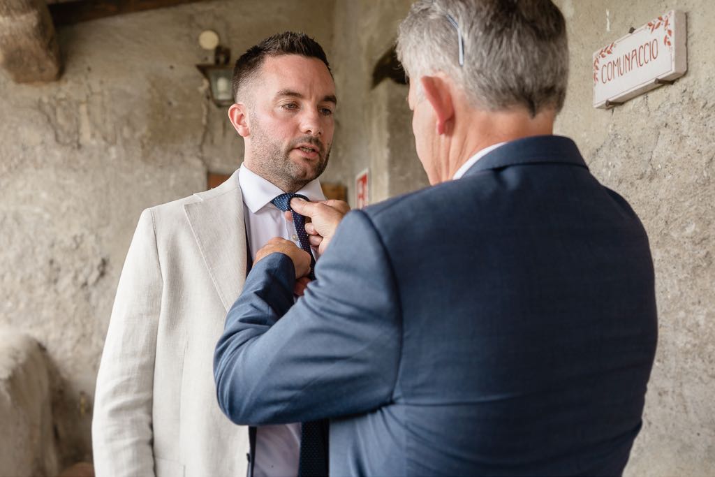 il papà sistema la cravatta dello sposo